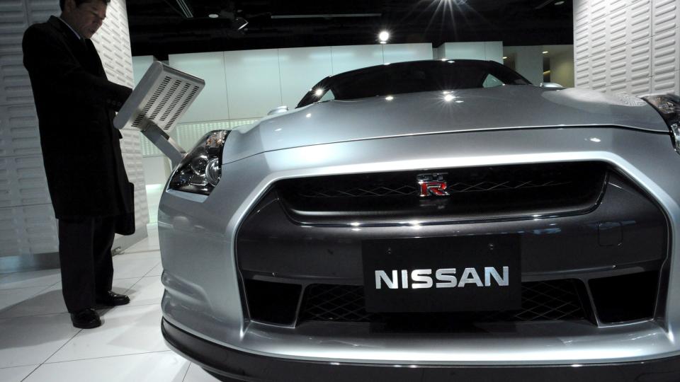 D�RLIGE NYHETER: Nissan m� gjennomf�re store kutt p� grunn av sviktende salg. Her ser en japansk bilforhandler p� en ny Nissan-modell under bilmessen i Tokyo. Foto: EPA/EVERETT KENNEDY BROWN/SCANPIX