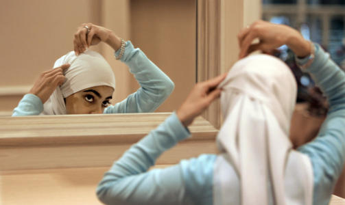 HIJAB-DEBATT:  Sadaf Butt fra Alabama retter p� hijaben foran speilet. Bildet av henne er brukt som illustrasjonsfoto og har ingen tilknytning til saken. Foto: AP Photo/M. Spencer Green/SCANPIX