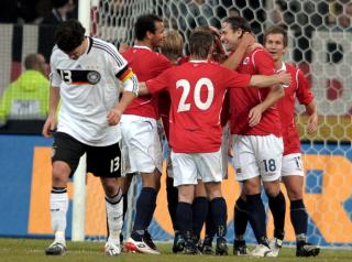 UTROLIG COMEBACK: Norsk jubel etter at Christian Grindheim ga Norge ledelsen 1-0. Tyske kaptein Ballack oppsummerer hjemmelagets kveld med kroppspr�ket.  Foto: SCANPIX/ EPA/FEDERICO GAMBARINI