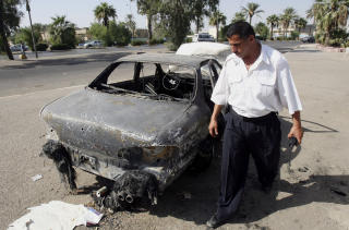 SKJ�T MOT SIVILE: En mann inspiserer et bilvrak p� Nisoor-plassen i Bagdad, der Blackwater �pnet ild mot sivile. Foto: AP Photo/Khalid Mohammed/SCANPIX
