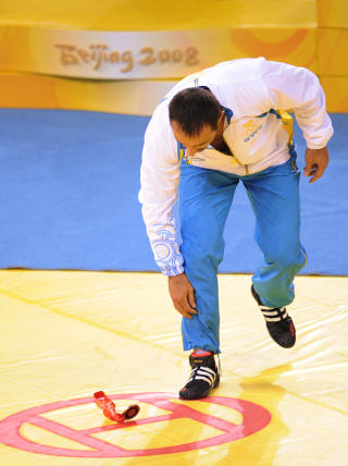 FIKK NOK: Her kaster Ara Abrahamian bronsen p� matta og forsvinner fra medaljeseremonien i protest mot det han mener er korrupsjon blant brytedommerne. Foto: AFP / Peter PARKS