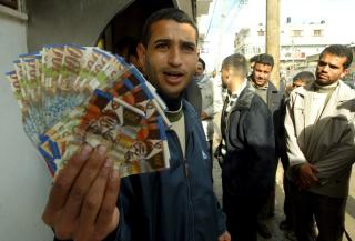 JA, BANKEN VIRKER! Et palestinsk medlem av Fatah viser fram januarl�nna si, som han fikk ut av minibanken i Rafah, s�r i Gaza, som viser at bankene begynner � fungere igjen. Foto: Abed Rahim Khatib/Epa/Scanpix