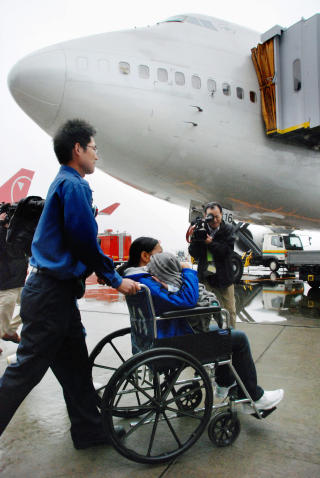 TURBULENT: 30 passasjerer ble skadd i uhellet. De ble m�tt av ambulanser og personell med b�rer og rullestoler. Foto: AP/Kyodo News