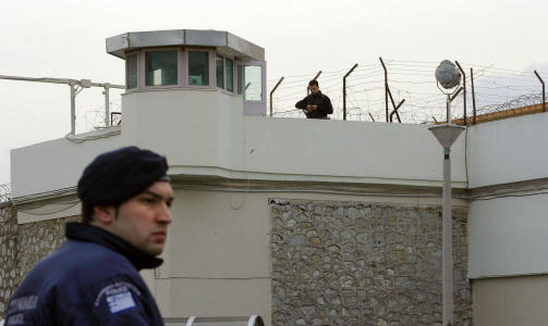  TUNGT BEVOKTET:  En vakt holder utkikk ved Korydallos-fengselet i Aten etter at to fanger r�mte derfra p� dristig vis s�ndag. FOTO:  AFP PHOTO / Losmi Bica/Scanpix