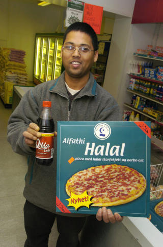 FOR FANGER: I 2003 ble muslimsk cola lansert i Norge. �Qibla-Cola� er muslimenes boikott-svar p� amerikanske Pepsi og Coca-Cola. Her viser Ajaya Karki frem muslimenes nye l�rdagskos, Qibla-cola og Halal-pizza. Foto: Heiko Junge / SCANPIX