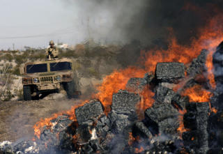 I FLAMMER: 14 tonn beslaglagt narkotika destrueres av myndighetene i Ciudad Ju�rez. Foto: J. Guadalupe Perez/AFP