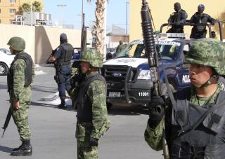 KRISEM�TE: Soldater vokter m�tet der innenriksministeren og medlemmer av delstatens sikkerhetsr�d diskuterer krisen i byen. Presidenten i Mexico, Filipe Calder�n, har satt inn 45 000 soldater for � bekjempe narkokartellene.Foto: AP