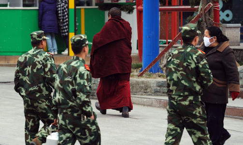 PREGER GATEBILDET: Kinesiske soldater patruljerer blant tibetanske munker og demonstranter i byen Kangding. Foto: AFP/Scanpix