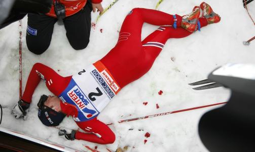 FULLSTENDIG UTMATTET: Uttrykk som l�tt og barneskirenn var erstattet med litt mer ydmyke � e s� sliten da en fullstendig utmattet Northug flatet sammen i m�lomr�det.  Foto: Lise �serud / SCANPIX