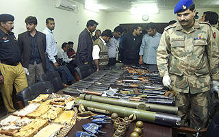 LIGNER MUMBAI: Pakistansk politi med v�pen  - deriblant granater og bombekastere - som gjerningsmennene etterlot seg etter angrepene i g�r formiddag. Foto: REUTERS / SCANPIX