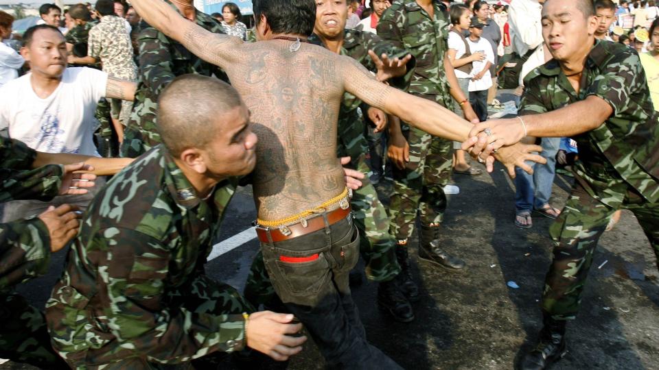 MISTET KONTROLLEN: Soldater m�tte ta h�nd om denne mannen under dagens festival. Foto: REUTERS/Chaiwat Subprasom/Scanpix
