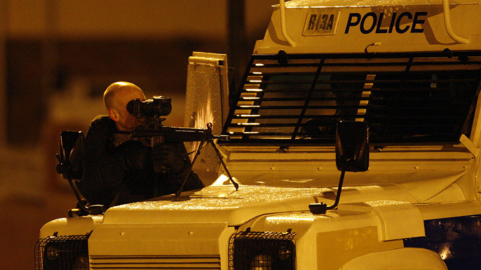 I HELSPEND: En nordirsk politimann sikter mens han holder vakt i n�rheten av stedet der en av kollegene hans ble drept i g�r. En rekke sikkerhetstiltak settes i gang etter det man tror er en aksjon fra irske terrorister. Foto: Peter Morrison/AP Photo/Scanpix