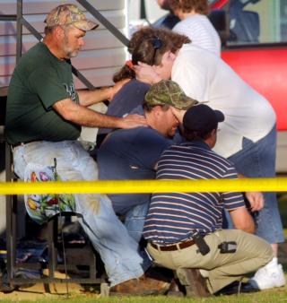  I SORG: Familiemedlemmer av de drepte tr�ster hverandre utenfor et hjem i Samson. Foto: AP Photo/The Dothan Eagle, Jay Hare