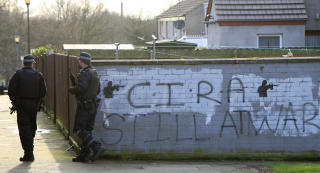 FORTSATT I KRIG: Politimenn g�r forbi veggen med ordene 'CIRA Still At War' i Craigavon i Nord-Irland. Bildet er fra i g�r. The Continuity IRA er imot alle fredsavtaler og vil ha et irsk Irland. Foto: AFP PHOTO/Peter MUHLY