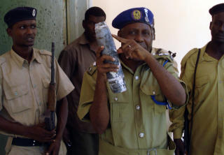 UTF�RER SELVMORDSANGREP: Al-Shabab rekrutterer selvmordsbombere og har kontakt med andre, store islamistgrupperinger. Her viser en politimann frem en bombekaster som Al-Shabab skal ha avfyrt i Mogadishu. Foto: AFP/ABDURASHID ABIKAR