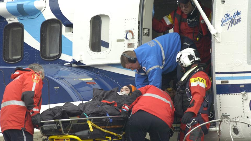 REDDES: En person reddes og fraktes til sykehus etter at et helikopter styrtet utenfor Canada. Men de andre 17 som var ombord er fortsatt savnet. Foto: Keith Gosse/St. John's Telegram/The Canadian Press/AP/Scanpix