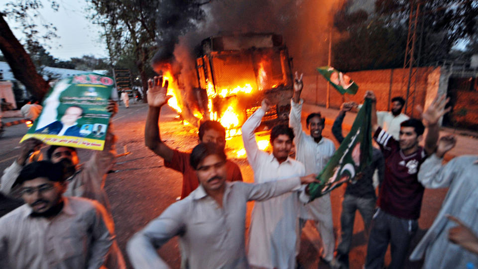 I FLAMMER: Demonstranter i Lahore satte blant annet fyr p� en politibuss i dag. Foto: AFP PHOTO/ Asif HASSAN/SCANPIX