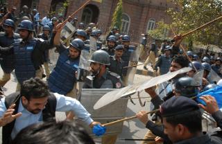 KAMPER: Pakistansk politi bruker batonger og t�regass mot demonstrantene. Foto: Khalid Tanveer/AP/Scanpix