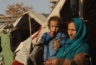 STOR FATTIGDOM: Mange unge, fattige menn har ikke s� mange andre valg enn � bli med p� en krigsherres side i kampene eller delta i opiumstrafikken. Bildet er fra en flyktningeleir i Kabul hvor det bor afghanere som har returnert fra Pakistan. Foto: AFP/SHAH Marai