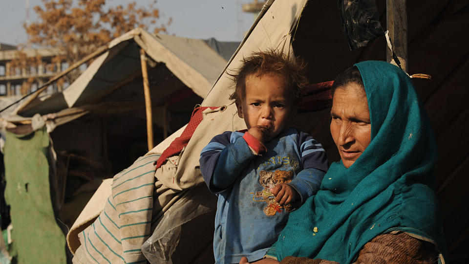 HJELPEARBEID: En afghansk mor og hennes barn sitter i en flyktningeleir i Kabul. Taliban vil straffe vestlige hjelpearbeidere med d�den. Foto: Marai Shah/AFP/Scanpix