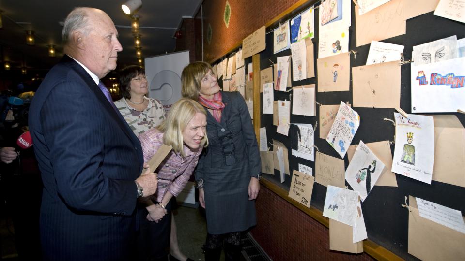 VENNLIGST FORSTYRR: Kong Harald, generalsekret�r i Redd Barna, Gro Brekken (th), barne- og likestillingsminister Anniken Huitfeldt og avdelingsleder i Redd Barna, Marianne Borgen (bak) ser p� en utstilling laget av 6. og 7. klassinger fra Hagen skole i Nittedal i forbindelse med premieren p� animasjonsfilmen Sinna mann. Den er en del av Redd Barnas kampanje mot vold mot barn, kalt Vennligst forstyrr!. Foto: Bj�rn Sigurds�n / SCANPIX