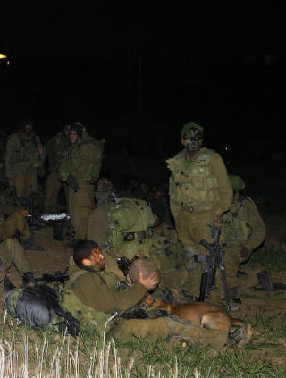 KLARE TIL � DRA INN:  Israelske soldater sitter ved grensa mellom Israel og Gaza, klare til � dra inn p� den overbefolkede stripen den 2. januar i �r, da Israel gjennomf�rte en massiv milit�roperasjon i Gaza. N� begynner vitnem�lene fra israelske soldater � komme. Foto: Jack Guez/Afp/Scanpix