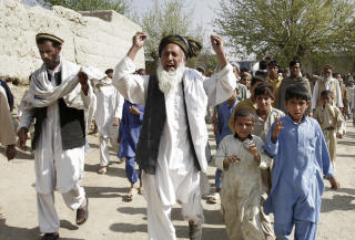 MOT USA OG AFGHANSKE MYNDIGHETER: En afghansk mann med slagord under en demonstrasjon i  Bati Kot-distriktet �st for Kabul i mars i �r. Innbyggerne kan i liten grad stole p� sentralmakten i landet, og vender seg derfor til krigsherrer og landsbyledere. Foto: AP/Rahmat Gul
