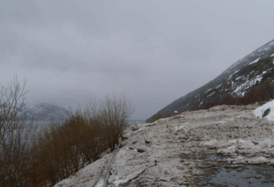 SPERRER VEIEN: Et 200 meter bredt sn�ras har feid over Riksvei 17 i Rana. Rednignsmannskaper s�ker n� i skredet og i vannkanten, det er forel�pig uvisst om noen er tatt av raset. Foto: Nils Forsbakk