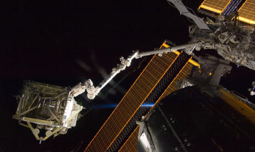 UT MED LASTA: Romfergas robotarm laster ut panelene som gir bedre str�mforsyning til romstasjonen. Foto: AFP PHOTO/HO/NASA/SCANPIX