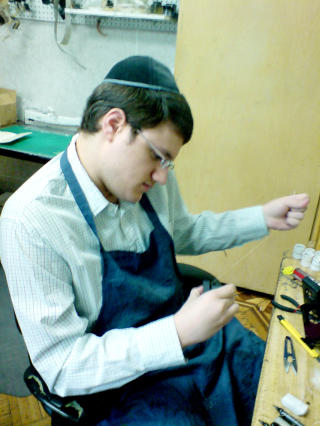 KUHALEH�R ER KOSHER: Denne verkstedsansatte syr sammen kuskinnet med h�r fra kuas hale. Foto: ASTRID MELAND