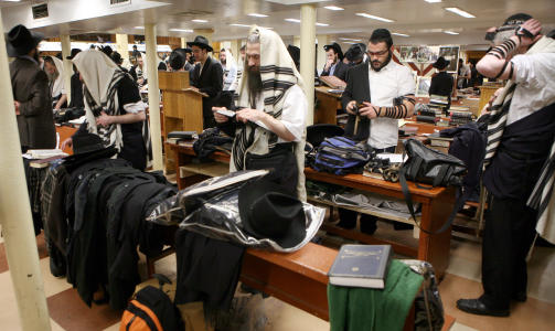 INGEN KVINNER TILLATT: Her gj�r de troende seg klare til � be i synagogen i hovedkvarterer i Eastern Parkway i Brooklyn. Mange hundre menn samles til religi�s samhandling her hver fredag. Foto: AP/David Karp