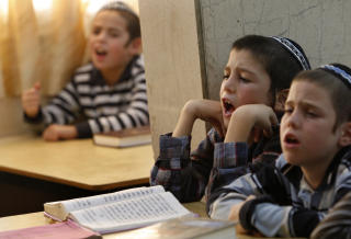 L�RER VANLIGE FAG I BARNESKOLEN: N�r barna blir ten�ringer er fokuset p� religion. Disse ultraortodokse barna ber p� skolen i Kfar Chabad i Israel. Foto: REUTERS/Gil Cohen Magen