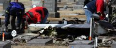 NTSB investigators and local authorities scour the scene near the wing of the downed aircraft at Holy Cross Cemetery, scene of the fatal plane crash which killed 14 people on Sunday, adjacent to the Butte Airport in Butte, Mont., on Tuesday, March. 24, 2009. (AP Photo/Mike Albans)