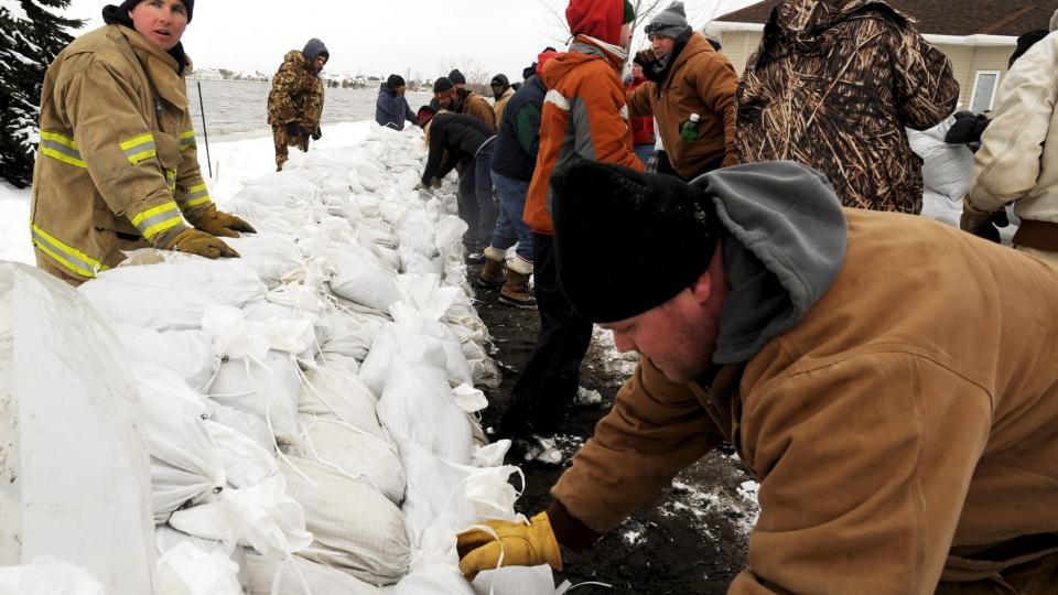 BYGGER SIKKERHETSMUR Brannvesenet i Fargo jobbet i g�r p� spreng for � verne seg mot de stigende vannmengdene fra elva Red river ved byen Fargo i North Dakota. N� i natt lokal tid har en av demningene kollapset. Foto: EPA/CRAIG LASSIG/SCANPIX