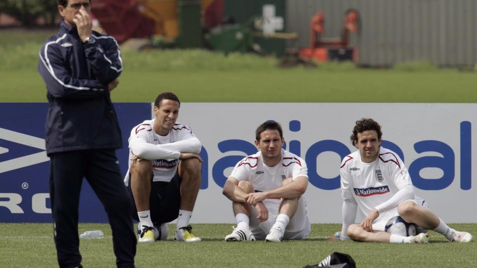 MANGE UTE: Rio Ferdinand (sittende ved siden av Fabio Capello) er en av mange spillere som mangler for England for tida. Foto: AP/Lefteris Pitarakis