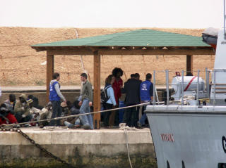 REDDET: Flyktninger ankommer den italienske �ya Lampedusa etter at den italienske kystvakta reddet dem opp av vannet. Foto: AP/SCANPIX