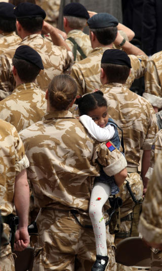 LOKAL P� BES�K: Britisk soldat holder et irakisk barn p� armen under sermonien. Foto: ESSAM AL-SUDANI/AFP