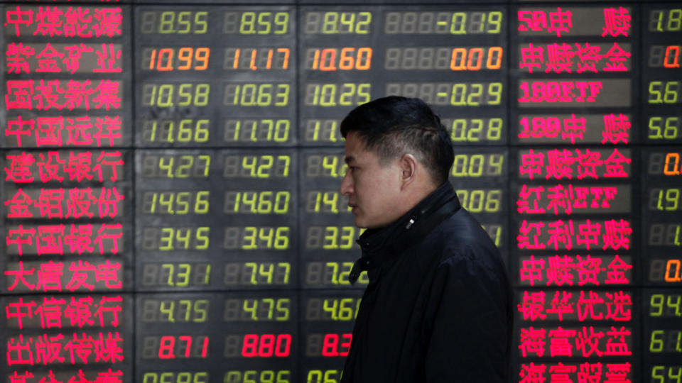 DYSTRE UTSIKTER: En investor passerer en oversikt over aksjekurser i Shanghai i Kina. Foto: Eugene Hoshiko/AP