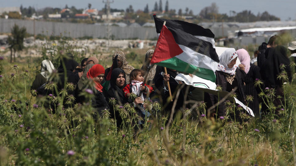 VIL HA PALESTINSK ENHET:  Palestinske kvinner holder det palestinske flagget h�yt i lufta p� den nordlige Gaza-stripen, like ved den israelske grenseposten Erez, som skiller Gaza og Israel. Kvinnene markerte i g�r den palestinske landdagen. Foto: Mohammed Abed/Afp/Scanpix