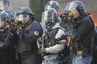  Over 20 000 politimenn var hentet inn for � stagge demonstranter. De brukte sjokkgranater og t�reg�ss i sine fors�k p� � spre oppr�rerne. Foto: AP Photo/Christophe Ena/SCANPIX