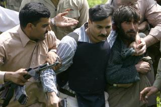 STORMET POLITISKOLE: En mistenkt terrorist blir f�rt bort av pakistanske sikkerhetsstyrker, etter stormingen av en politiskole i Lahore denne uka. Foto: REUTERS/Mohsin Raza/SCANPIX