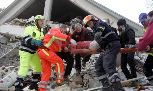REDDET UT: Redningsmannskapene redder ut en kvinne fra ruinene i Aquila. Vanlige mennesker er aktive i redningsarbeidet sammen med brannmannskaper og Sivilforsvaret. - Det var vanlige innbyggere som dro meg fram fra ruinene med bare hendene, sier 23 �r gamle Guido Mariani, som ble reddet etter � ha ligget fanget i tre timer. Foto: Pier Paolo Cito/Scanpix