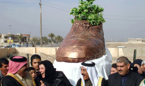 HYLLES: Den fengslede journalisten er blitt en folkehelt blant mange irakere. Her avdekkes en skoskulptur i bronse i Saddam Husseins hjemby Tikrit - til �re for skoene som nesten traff Bush. Foto: AFP/MAHMUD SALEH/SCANPIX