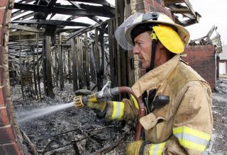 TUNG JOBB: Brannmann Bill Lott pr�ver � redde restene av et nedbrent hus. Foto: EPA/Bill Waugh/Scanpix