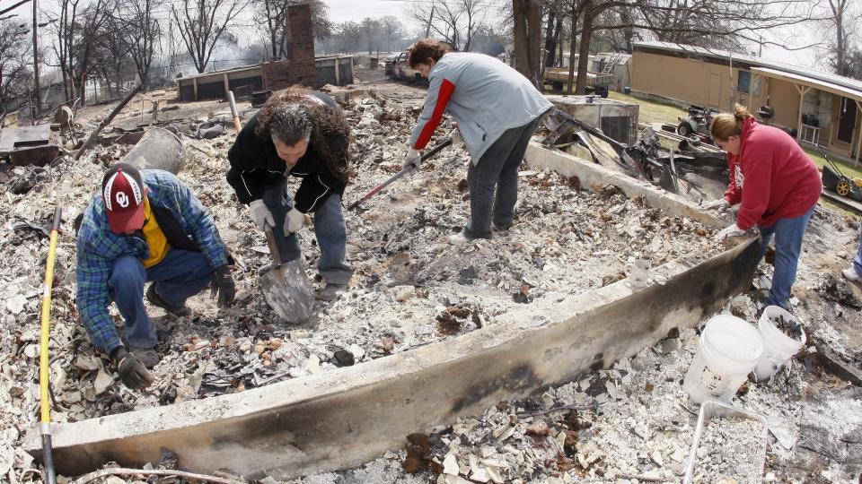STORE SKADER: Rene Holbrook og LaRay Brown (i midten) f�r hjelp av venner til � se etter uskadde eiendeler etter at huset deres har brent ned til grunnen i Midwest City i Oklahoma. Brannen er trolig p�satt. Foto: EPA/Bill Waugh/Scanpix