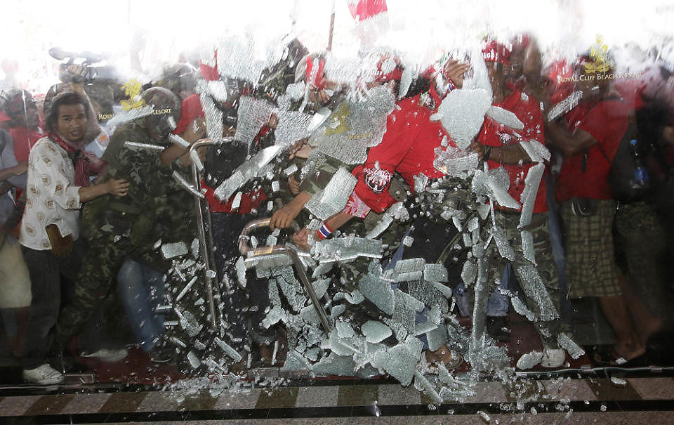 LOT SEG IKKE STOPPE: Demonstranter baner seg vei gjennom glassd�ra inn til et av Asean-toppm�tets lokaler i Pattaya tidligere i dag. Foto: SUKREE SUKPLANG/REUTERS/SCANPIX