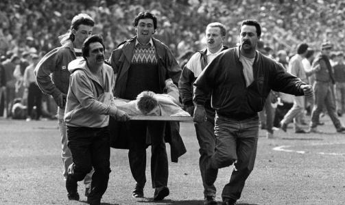 KAOS: Det hersket fullt kaos inne p� Hillsborough da tragedien var et faktum. Her blir en skadd person b�ret bort p� et reklameskilt. Foto: CAMERA PRESS