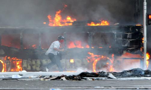 SATT I BRANN: Demonstrantene krever at regjeringen trekker seg og statsminister Abhisit Vejjajiva g�r av. I dag ble en rekke busser og bygninger tilknyttet regjeringskvartalet satt i brann. Foto: Scanpix