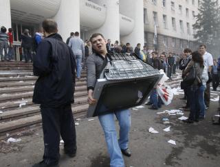 TOK SEG INN I PARLAMENTSBYGNINGEN: En demonstrant tok med seg en TV under protesten 7. april. De kastet ogs� m�bler og datamaskiner p� gata, og bygningen ble satt i brann. Foto: REUTERS/Gleb Garanich