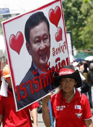 MANGE ST�TTESPILLERE: Tilhengere av Thailands eksstatsminister Thaksin Shinawatra b�rer med seg et bilde av det styrtede regjeringssjefen etter � ha avsluttet en okkupasjon i regjeringsomr�det i Bangkok i dag. Foto: REUTERS/SCANPIX